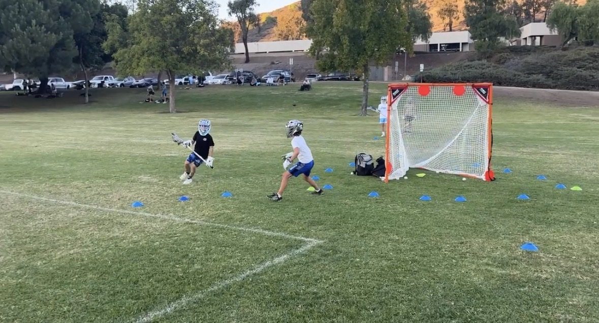 Sessions Lacrosse players in a drill near goal